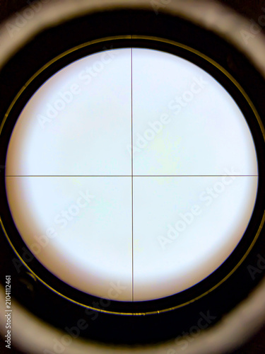 Photography Microscope eyepiece view with 10x reticle featuring crosshair and reference markers on a uniformly illuminated field used for optical alignment and calibration