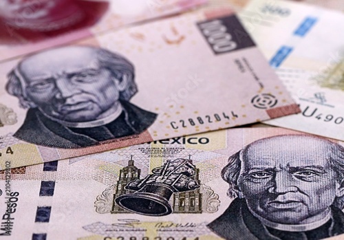 Mexican peso money bills pile on table. Mexico banknotes of MXN currency close up.