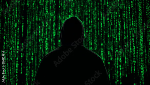 Obraz w ramie 降り注ぐ緑のマトリックスバイナリコードの壁に向き合う黒いフードの後ろ姿のハッカーシルエット