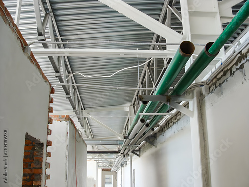 Industrial building interior with exposed pipes and unfinished walls