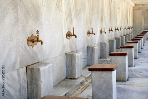 Bild auf Leinwand Beautiful bronze taps for ablution of Muslim believers at the entrance to the courtyard of the mosque