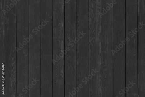 A black wooden wall with vertical planks. A dark timber surface texture.