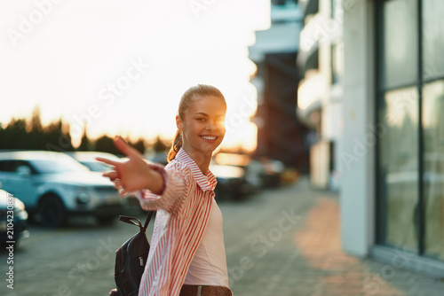 Bild auf Leinwand Woman lifestyle on a city street, smiling and pointing playfully, casual outfit,