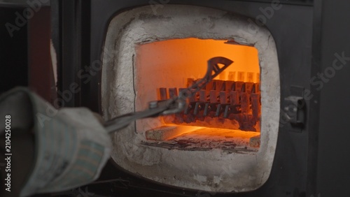 Cuadro en lienzo A blacksmith opens a glowing furnace, places a knife blade inside, and closes the furnace during the metal quenching process