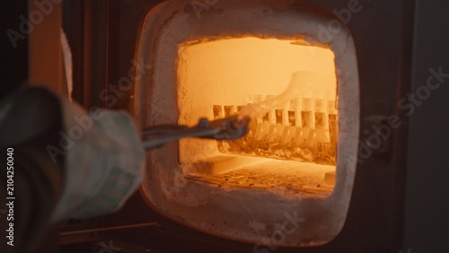 Cuadro en lienzo A blacksmith opens a glowing furnace, places a knife blade inside, and closes the furnace during the metal quenching process