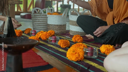 The Altar flowers and candles sits on a wooden floor.
