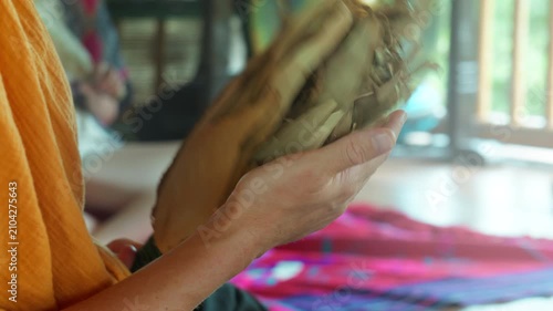 Girl's hands play a shamanic instrument from South America. The tool is called Chacapa.