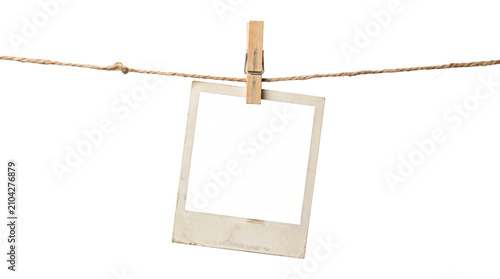 Obraz na plátně Vintage polaroid paper photo frame hanging on rustic twine rope with wooden clothespin isolated white