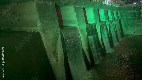 Video footage of a hydroelectric dam with flowing water, captured in a dramatic industrial setting.