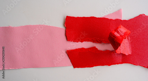 Cinta adhesiva roja rasgada sobre papel rosa con efecto de desgarro y espacio para texto