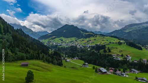 interesting panoramic view to the little valley of Walser and the rocky mountains from Vorarlberg. little villages and many mountain peaks behind, interesting sky with waves clouds, hiking and skiing 