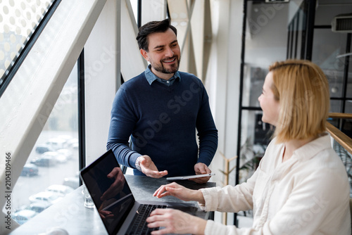 Business meeting taking place in a modern office during the day with two people talking
