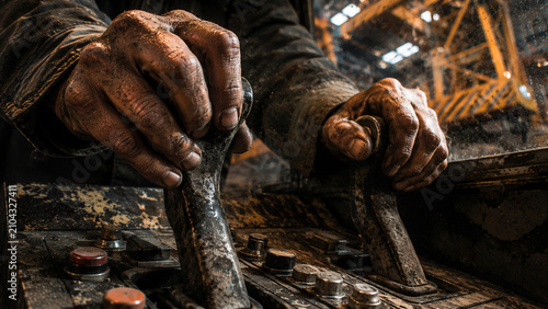 Tableau sur toile Crane operator hands holding control levers in industrial factory workstation