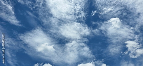 Slika na platnu A clear blue sky with feathery or filamentous clouds mixed with smaller clumps scattered across the sky