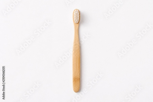 A minimalist and eco-friendly bamboo toothbrush, presented on a clean white surface for a simple aesthetic.
