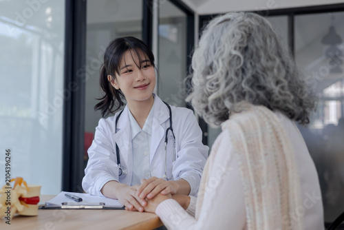 Schilderij op canvas Smiling doctor holding senior patient's hands to offer support