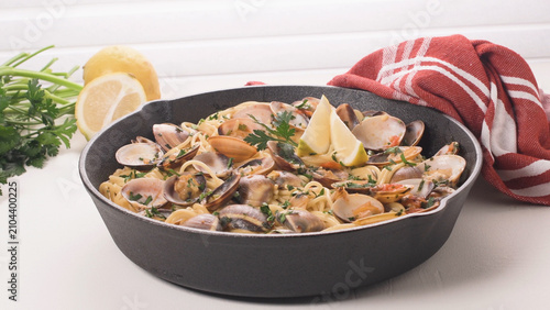 Obraz na płótnie Spaghetti alle Vongole with Fresh Clams and Lemon in a Cast Iron Skillet