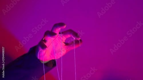 Hand with Puppet Strings in Neon Pink Light — Control and Manipulation Concept
