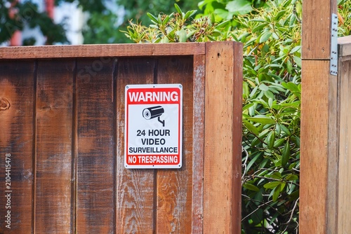 Bild auf Leinwand Video surveillance and no trespassing warning sign on wooden fence