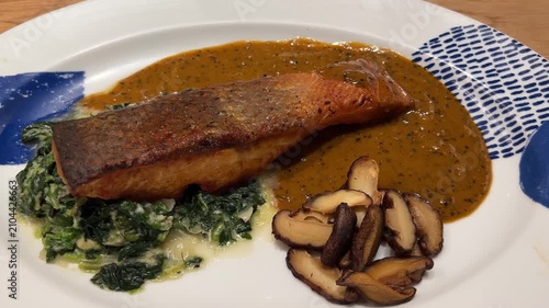 Salmon Steak with Pepper Sauce and spinach and Mushroom Served in Restaurant