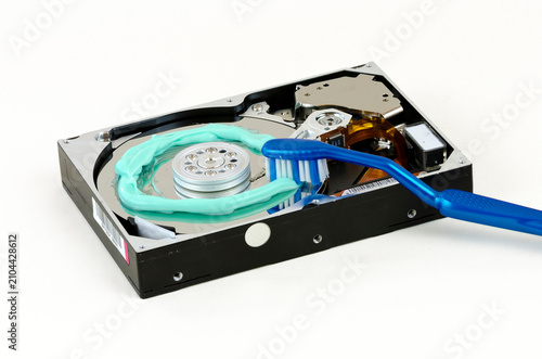 symbolic depiction of cleaning an opened harddisc with blue toothbrush and toothpaste