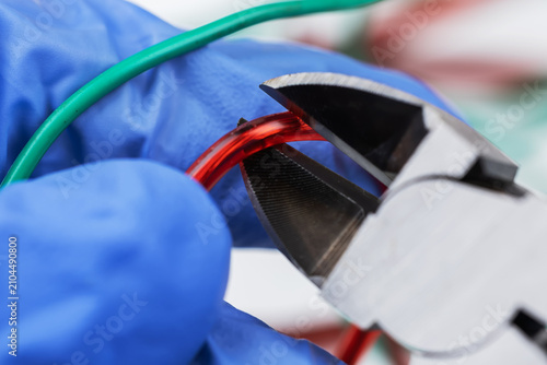 electrician at work with nippers in hand cut the electric cable, electrical wiring. selective focus