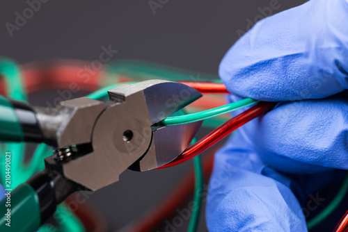 electrician at work with nippers in hand cut the electric cable, electrical wiring. selective focus