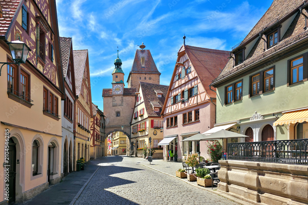 Obraz premium Picturesque street of colorful half timbered buildings and medieval Markus Tower in the town of Rothenberg ob der Tauber, Bavaria, Germany