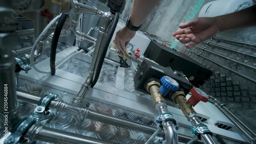 HVAC Technician Adjusting Heat Pump and Boiler System in Modern Mechanical Room