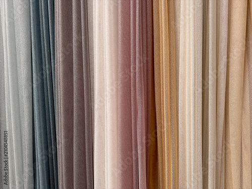 Soft gradient of sheer fabric panels in muted earthy tones. A collection of translucent textile drapes displaying a subtle color transition from light grey to warm beige. Close-up abstract background 