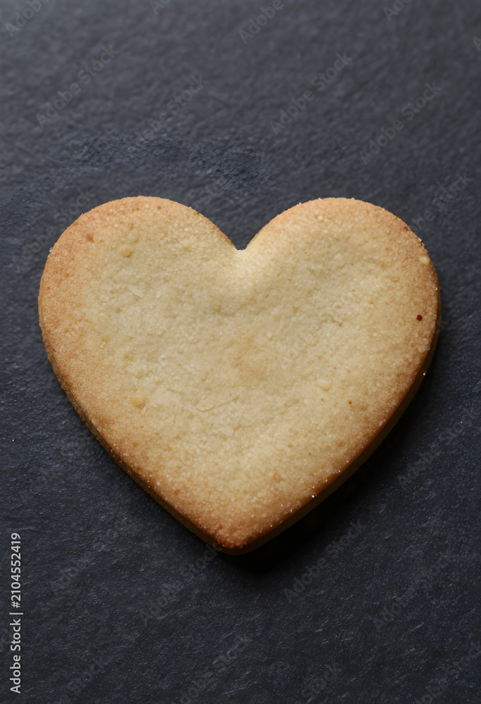 Obraz premium Heart-shaped cookie on dark background