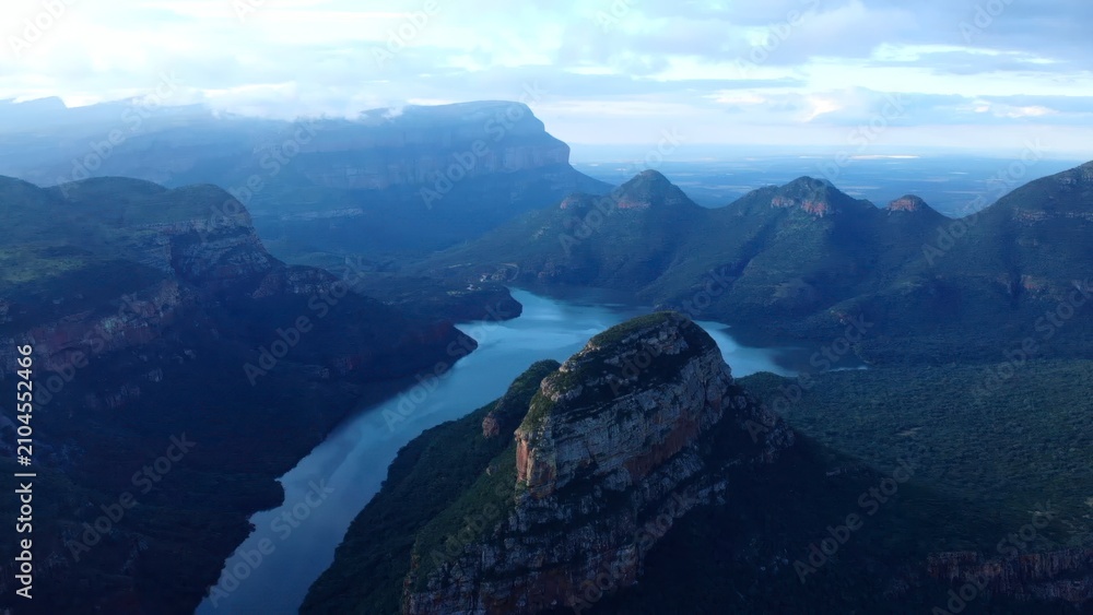 Obraz premium Dawn Over Rugged Cliffs And Flowing Waters. Majestic Canyon River With Mist And Golden Sunlight At Dawn . Media