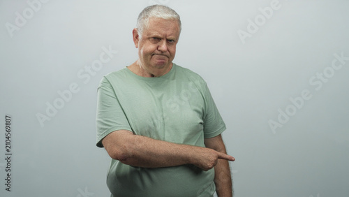 Konstfotografi Man points finger to right with pursed lips and slight frown wearing green t shirt in studio; disapproval direction