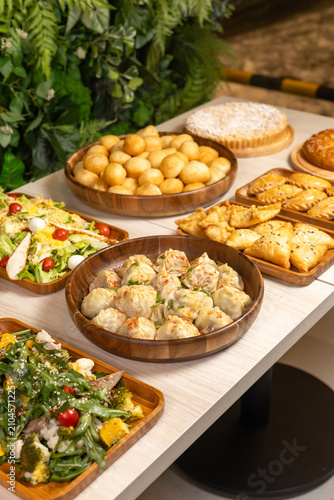 Festive Central Asian food table with manti dumplings baursaks and fresh salads