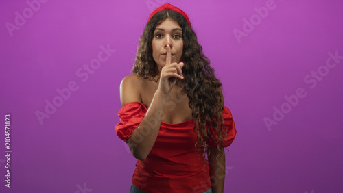 Canvastavla Woman with finger to lips for silence in studio wearing red top and headband; silence secrecy hush mystery