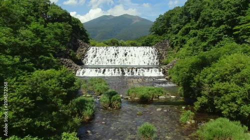 山々を望む河川の堰と清流を空撮