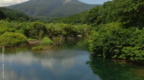 山々に囲まれた静かな水辺の自然風景を空撮