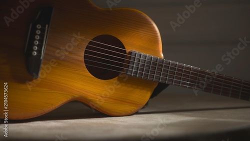 Close-up acoustic guitar resting on a soft surface