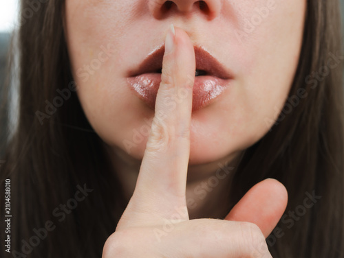 Photos Sensual Caucasian woman putting finger on her glossy lips making hush sign