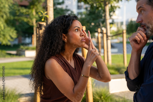 Couple arguing on a city sidewalk. Man and woman having a disagreement in an urban street setting. 