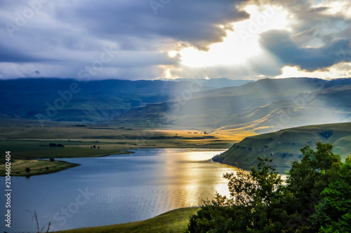solar flare and sun rays over Maloti Drakensberg mountains and bell park dam