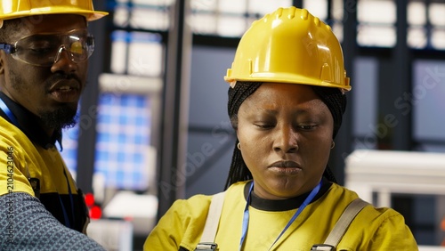 Photos Solar plant engineering team using a laptop to oversee machinery systems; photovoltaic plant colleagues use software on a laptop to maintain operations