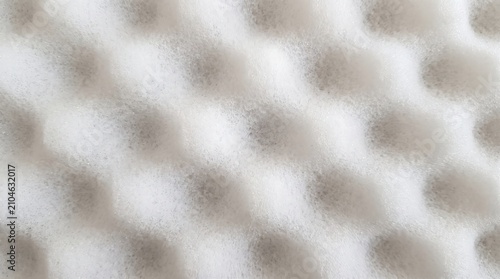 Close-up texture of white foam material with a distinctive honeycomb pattern, providing a soft and plush surface for various applications