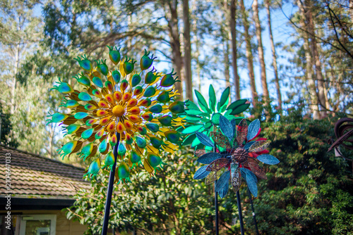 Foto Colorful Metal Wind Spinners in a Lush Garden, Symbolizing Whimsy and Joy Outdoo