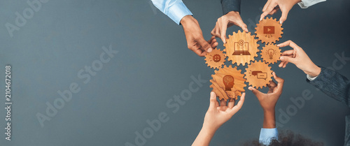 Foto Diverse hands unite around symbolic gears, representing ideas and collaboration
