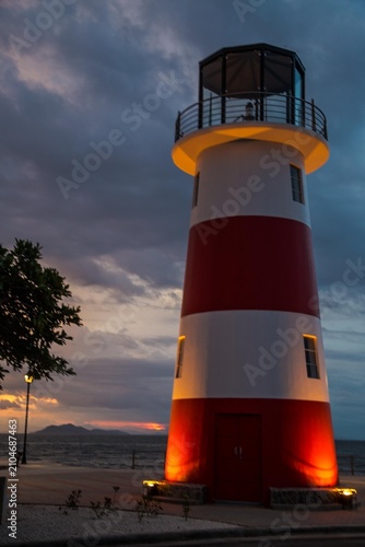 Puntarenas, Costa Rica, Lighthouse by the beach at sunset, serene atmosphere, perfect for travel and adventure photos.
