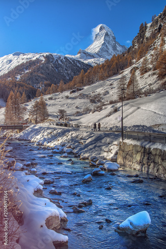 Snowy Matterhorn with stream and people walking High quality commercial imagery suitable for marketing, advertising, editorial use, and professional s