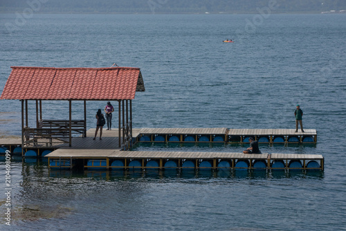 People on a lake dock enjoying the view High quality commercial imagery suitable for marketing, advertising, editorial use, and professional stock cat