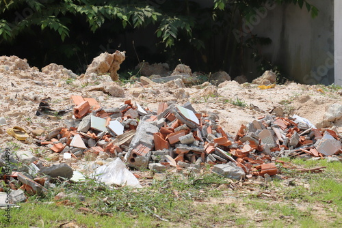 Mixed construction debris scattered on ground after demolition at outdoor building renovation project