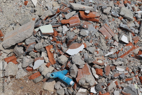 Scattered construction rubble containing shattered bricks, concrete fragments, and debris across demolition site